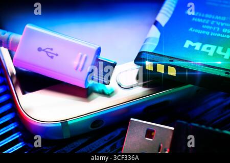 Akku und USB-Kabel an einem Smartphone Stockfoto