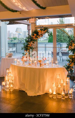 Eleganter Hochzeitsempfang mit Blumendekoration und Kerzenlicht in einem modernen Raum Stockfoto