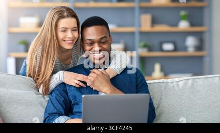 Portrait Von Happy Happy Young Multikulturelle Ehepartner Mit Laptop Bei Zu Hause Stockfoto