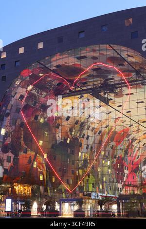 Rotterdams Wahrzeichen Markthal, erbaut 2014, entworfen von MVRDV's Winy Maas, mit 228 Apartments über einer Markthalle, die abends beleuchtet werden. Stockfoto
