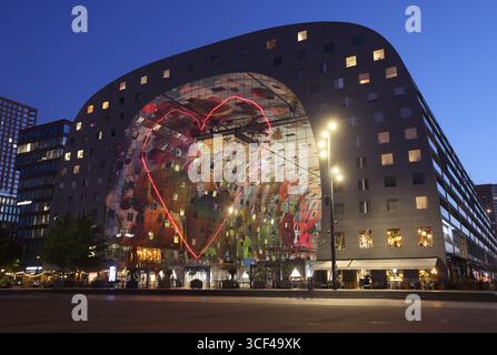 Rotterdams Wahrzeichen Markthal, erbaut 2014, entworfen von MVRDV's Winy Maas, mit 228 Apartments über einer Markthalle, die abends beleuchtet werden. Stockfoto