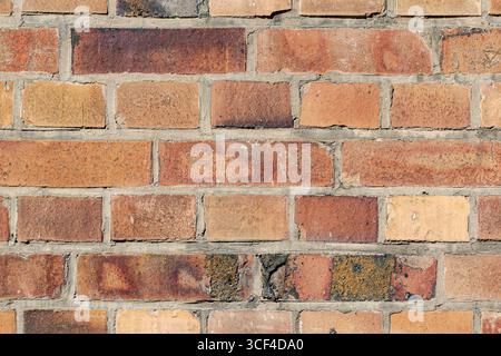 Helle, farbenfrohe Ziegelsteine in warmen Tönen von Orange bis Gelb, sonnendurchflutete und lebhafte. Stockfoto