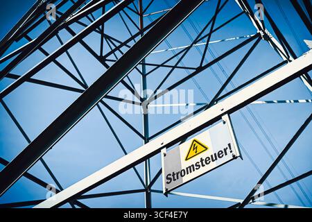 Hochspannungspylon mit Schild und Aufschrift Stromsteuer, Fotomontage Stockfoto