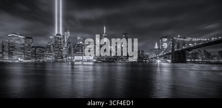 Skyline von New York City mit Brooklyn Bridge und Tribute in Light at Night Stockfoto