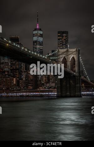 Brooklyn Bridge und One World Trade Center bei Nacht beleuchtet Stockfoto