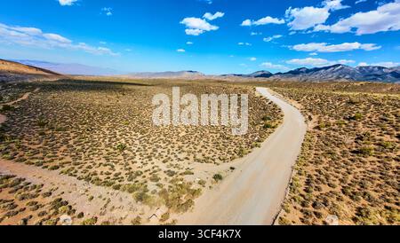 Aerial Desert Road und Mountain Range in der Nähe des Mt. Charleston Nevada unter Blue Sky Stockfoto