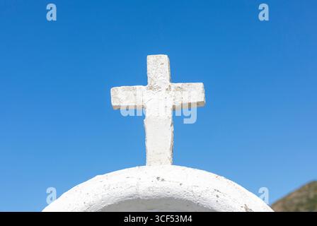 Das weiße Kreuz erhebt sich auf einer weiß getünchten Kuppel und bildet einen wunderschönen Kontrast zu einem tiefblauen Himmel, der Gefühle von Spiritualität, Gelassenheit und tief verwurzeltem Glauben an die Religion weckt Stockfoto