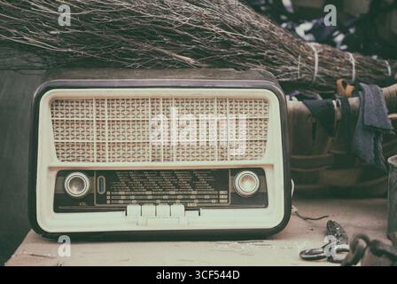 Vintage Radio auf Holztisch mit verschiedenen Utensilien Stockfoto