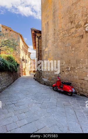 Roter Roller auf einer Straße in der Altstadt von Montichiello in Val d Orcia, Toskana, Italien. Stockfoto