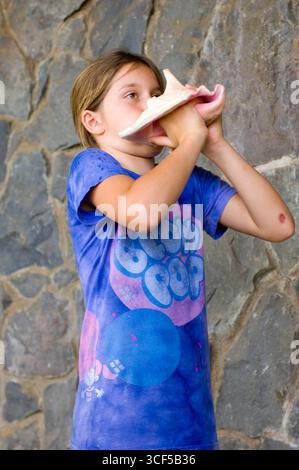 3. Grundschule Schüler hineinblasen Muschelschale als eine uralte Hawaiianische Methode immer Aufmerksamkeit und zu kommunizieren. Stockfoto