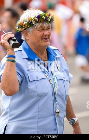Weibliche Sicherheitsbeamte mit Blumengirlande während des Punahou Schulkarnevals in Honolulu, Oahu, Hawaii, USA. Der Punahou Karneval 2006 wird gesponsert b Stockfoto