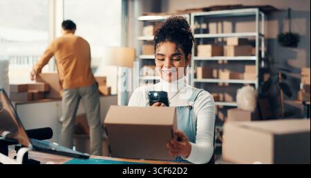 Box, Logistik und Telefon mit Frau im Vertriebsbüro für Barcode-Scannen oder Inventar. Paketverfolgung, Foto und Lieferkette mit Stockfoto