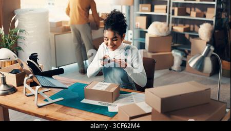 Box, Telefon und Lieferkette mit Frau im Vertriebsbüro für die Inventar- oder Paketverfolgung. Barcode-Scannen, Logistik und Fotografieren mit Stockfoto