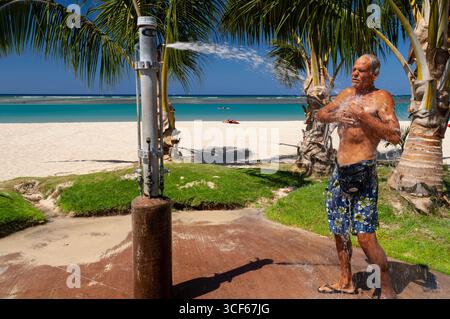Mann, der im Freien duscht, um das Salzwasser abzuwaschen, Ala Moana Beach Park, Honolulu, Oahu, Hawaii, USA Stockfoto