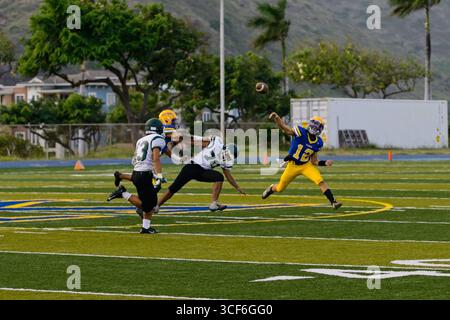 High School Quarterback startet einen Tiefpass, gefrorenen Mittelwurf mit Ball im Flug – perfekte Form, perfekte Fokussierung. Stockfoto
