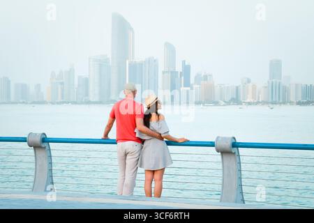 Kaukasische Touristen romantische Paare stehen zusammen und genießen das Panorama der Skyline auf dem malerischen Aussichtspunkt in Abu dhabi. Besuchen Sie die Reise Sightseeing VAE Concept Stockfoto