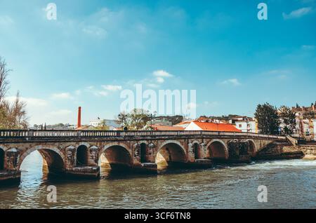 Weite Panoramaaussicht auf Tomar in Portugal, mit dem Fluss Nabão, dem historischen Schloss auf dem Hügel, malerischen weißen Häusern mit roten Dächern und dem Fluss Stockfoto