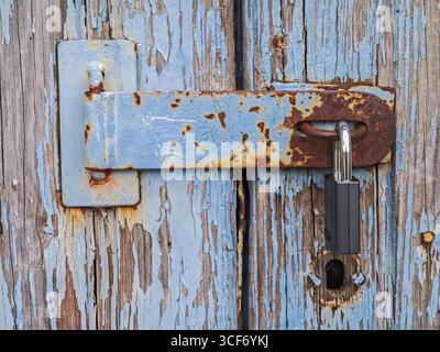 Holztür mit silbernem Schloss und abblätternder blauer Farbe, Kiel, Schleswig-Holstein, Norddeutschland Stockfoto