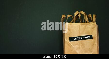 Black Friday-Shopping-Konzept. Schwarzer Freitag-Aufkleber auf nachhaltigen Papiertüten. Verkaufsbanner für Einkäufe, Konsum, Verkaufsangebote, Verkäufe 2025 Stockfoto
