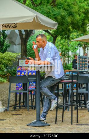 Männlicher Kellner oder Mitarbeiter im Restaurant/Bistro, der eine Zigaretten- und Kaffeepause in der Altstadt von Tours, Indre-et-Loire (37), Frankreich macht. Stockfoto