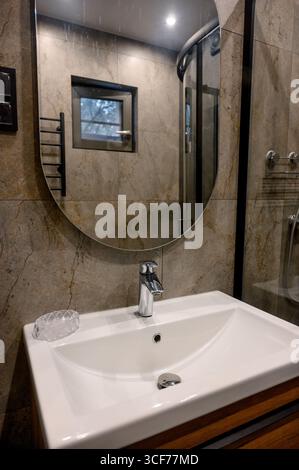 Modernes Badezimmer im luxuriösen Apartment. Graue Marmorfliesen. Weißes Waschbecken Stockfoto