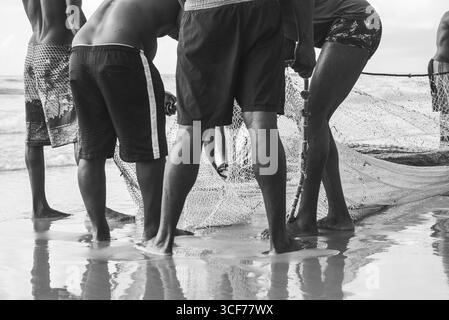 Ein halber Körper von nicht identifizierten Fischern, die ein Fischernetz ziehen. Angelsport. Brasilien Stockfoto