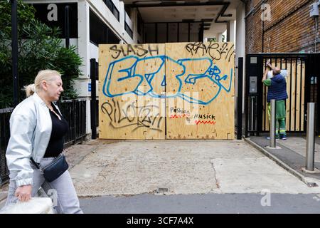 London, Großbritannien. August 2025. Eine Frau läuft an einem Wohngebäude vorbei, das in Notting Hill, westlich von London, vor dem Notting Hill Carnival, verschlossen ist. Quelle: SOPA Images Limited/Alamy Live News Stockfoto