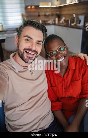 Glückliches Multi-ethnisches Paar, das zu Hause ein Selfie macht Stockfoto
