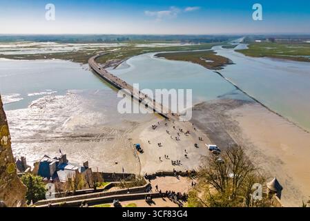 Durch das Wheel Room Fenster entfaltet sich ein weicher Blick auf die Bucht, ihre weite Umgebung und die moderne Brücke zum Mont-Saint-Michel auf einem sonnigen... Stockfoto