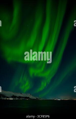 Leuchtend grüne aurora Borealis (Nordlichter) tanzen am Nachthimmel über den Bergen Islands. Stockfoto