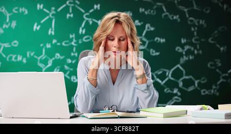 Überarbeiteter Professor Müde Und Frustriert Im Überfüllten Universitätsklassenzimmer. Chemiebuch. Stockfoto
