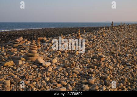 Türme aus Steinen an einem Strand, Holy Island, Northumberland, England, Großbritannien Stockfoto