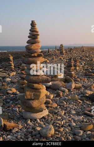 Türme aus Steinen an einem Strand, Holy Island, Northumberland, England, Großbritannien Stockfoto