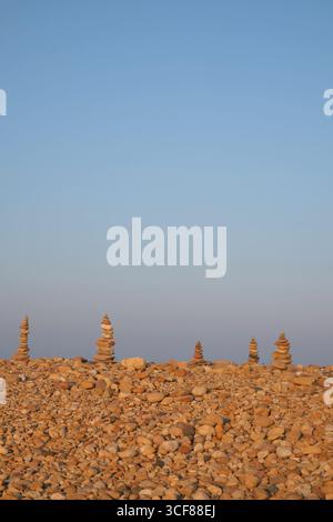 Türme aus Steinen an einem Strand, Holy Island, Northumberland, England, Großbritannien Stockfoto