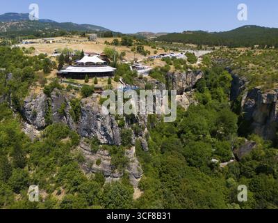Gebäude auf Felsen umgeben von üppigen Bäumen und Panoramablick über die Landschaft im Sommer, aus der Luft, Kristallglasterrasse, Terrasse, Kristal Cam Teras Stockfoto