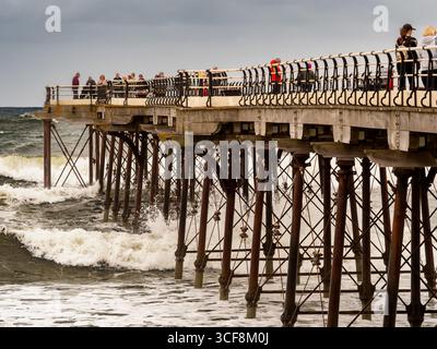 Raue Wellen aus der Nordsee treffen auf die Stahlböcke des viktorianischen Piers in Saltburn, North Yorkshire, Großbritannien. Stockfoto