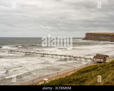 Ein Blick aus einem hohen Winkel auf den Saltburn Pier und die zerklüftete Küste mit Hunt Cliff, an einem bewölkten Tag in North Yorkshire, Großbritannien. Stockfoto