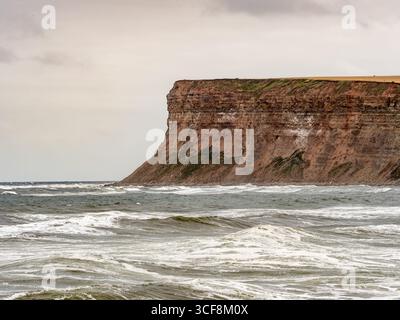 Eine Nahaufnahme der imposanten, geschichteten Felswände von Hunt Cliff an der Küste von Saltburn-by-the-Sea in North Yorkshire, Großbritannien. Stockfoto