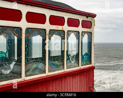 Detail der wunderschönen Buntglasfenster mit Seevögeln in einer Kutsche der historischen Saltburn Cliff Tramway in North Yorkshire, Großbritannien. Stockfoto