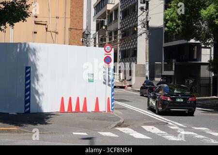 TOKIO, JAPAN - 19. August 2025: Zaun um eine Baustelle in Tokio. Es ist der Ort, an dem der heute abgerissene Nakagin Capsule Tower stand. Stockfoto