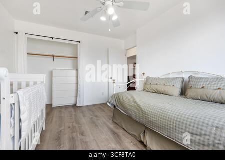 Geräumiges und gut beleuchtetes Schlafzimmer mit Kinderzimmer. Ideal für Familien mit modernem Design und komfortablen Möbeln. Stockfoto