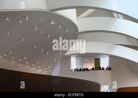 Besucher blicken von einem Innenbalkon im Guggenheim Museum in Bilbao, Nordspanien, Stockfoto