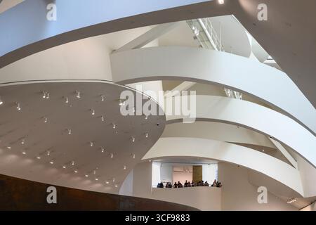 Besucher blicken von einem Innenbalkon im Guggenheim Museum in Bilbao, Nordspanien, Stockfoto