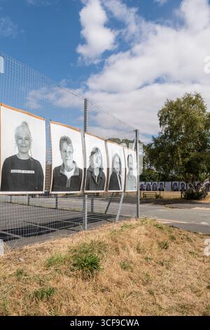 Eine Ausstellung von Community-Porträts lokaler Jugendlicher, die bis Ende August 2025 in Presteigne, Powys, Großbritannien, gezeigt werden. Es ist Teil des Inside Out-Projekts des französischen Künstlers JR, des größten globalen partizipativen Kunstprojekts überhaupt und des ersten in Wales. Die Porträts wurden von Cultivate erstellt, einer lokalen Jugendkunstgruppe, die vom Sidney Nolan Trust geleitet wird und von der Künstlerin Emma Posey (links) geleitet wird. Stockfoto