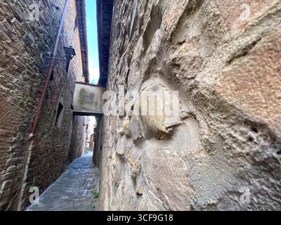 Kopfsteinpflasterallee mit überdachter Passage in Barberino Tavarnelle, Toskana, Italien, mit traditioneller italienischer Architektur und historischem Charme Stockfoto
