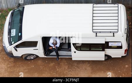 Nairobi, Kenia. August 2025. Das Bild zeigt einen Mann, der während eines Besuchs in Poa in einem Van auf sein Handy schaut! Internet in Nairobi, Kenia, am vierten Tag der belgischen diplomatischen Mission in Afrika am Donnerstag, 21. August 2025. Die belgische diplomatische Mission in Afrika findet vom 18. Bis 22. August 2025 statt. BELGA FOTO BENOIT DOPPAGNE Credit: Belga News Agency/Alamy Live News Stockfoto