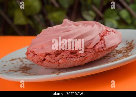 Nahaufnahme einer köstlichen rosa Merinque auf einer weißen Platte Stockfoto