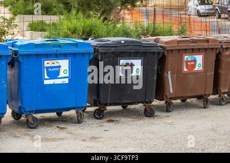 Gozo, Malta - 23. Juni 2021: Recyclingbehälter für Kunststoff, Metall und Glas stehen nebeneinander auf einer Straße. Stockfoto