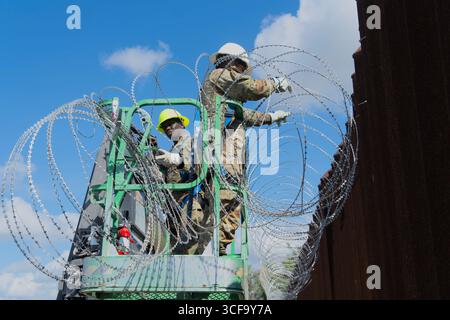 Brownsville, Usa. August 2025. Texas National Guardsmen, die unter der Joint Task Force-Southern Border arbeiten, installieren am 12. August 2025 in der Nähe von Brownsville, Texas, eine Drahtseile entlang der südlichen Grenzmauer zu Mexiko. Die Soldaten wurden von Präsident Trump zur Unterstützung der Operation Lone Star an die Grenze geschickt. Gutschrift: SSgt. Derek Gutierrez/US Air Force Photo/Alamy Live News Stockfoto