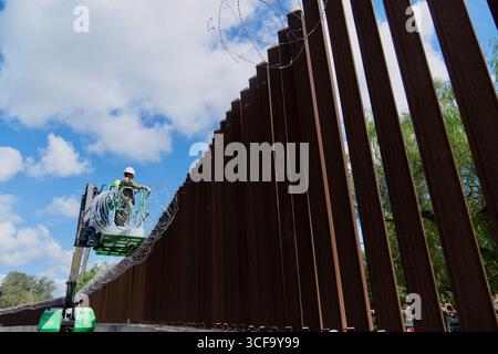 Brownsville, Usa. August 2025. Texas National Guardsmen, die unter der Joint Task Force-Southern Border arbeiten, installieren am 12. August 2025 in der Nähe von Brownsville, Texas, eine Drahtseile entlang der südlichen Grenzmauer zu Mexiko. Die Soldaten wurden von Präsident Trump zur Unterstützung der Operation Lone Star an die Grenze geschickt. Gutschrift: SSgt. Derek Gutierrez/US Air Force Photo/Alamy Live News Stockfoto